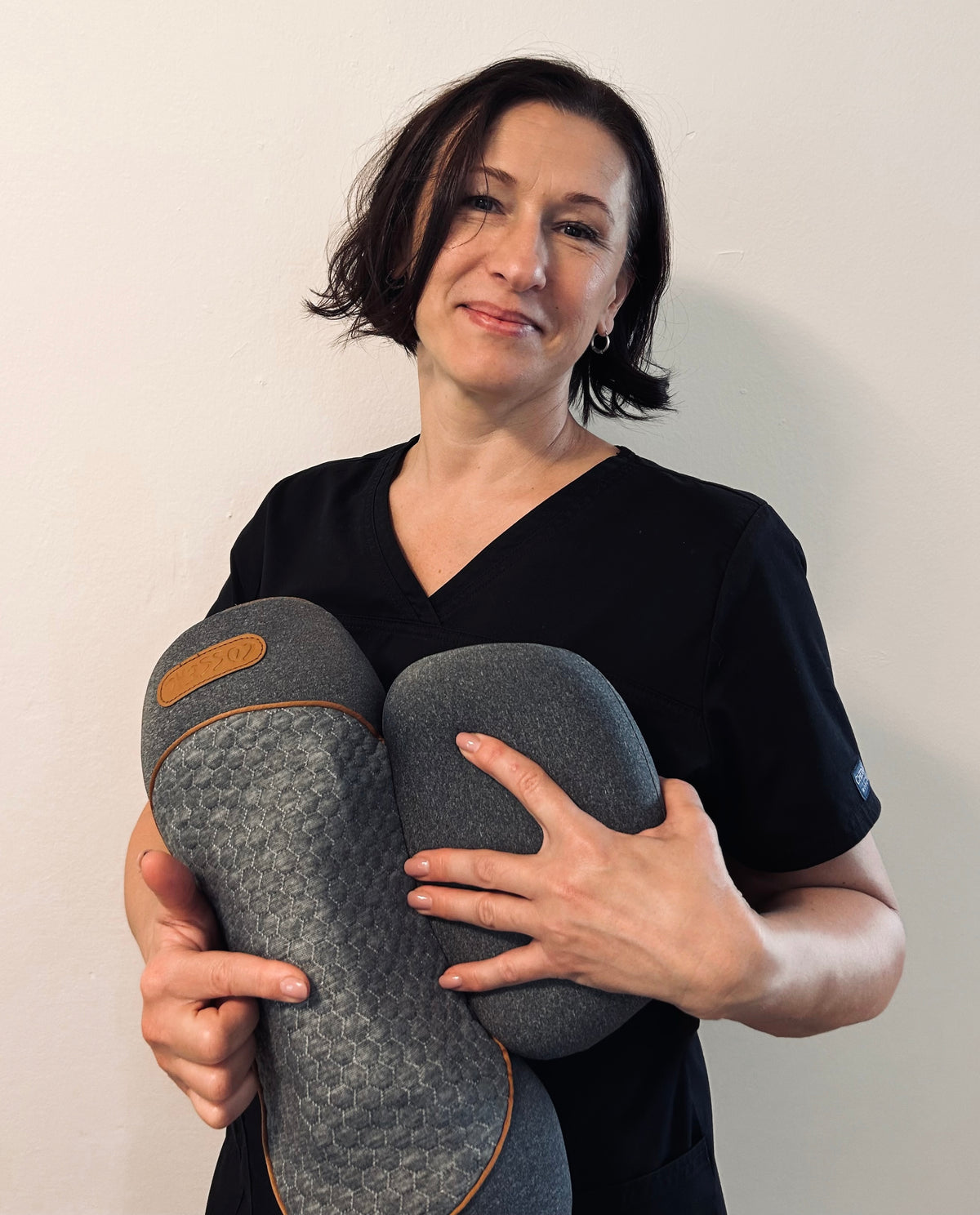 Woman holding the CloudRest neck pillow at home